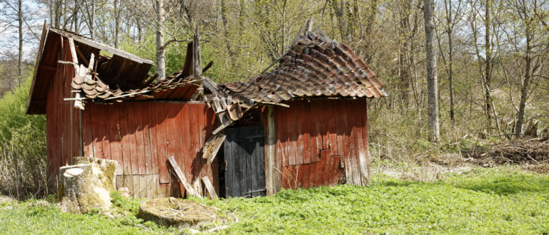 Rött litet hus som förfallit
