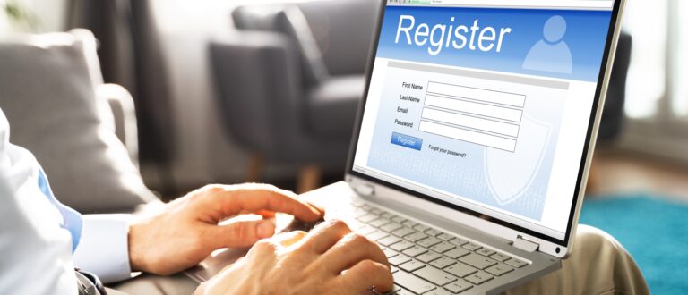 Man med laptop i famnen. På skärmen finns en registreringssida