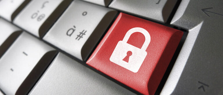 Ett grått tangentbord. En knapp är röd och har en symbol i form av ett lås.
