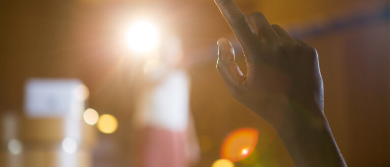 En människa deltar aktivt på ett evenemang genom att hålla upp sin hand