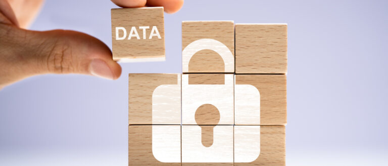 Några träblock som tillsammans bildar en helhet och bilden av ett lås. På en av klossarna står det data.
