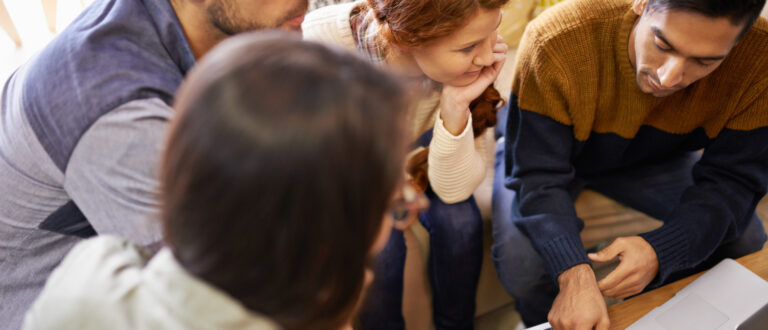 En grupp unga vuxna som arbetar tillsammans vid ett bord