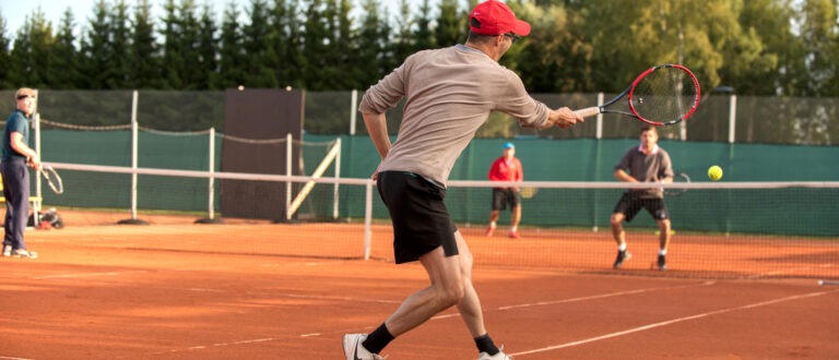 Två personer spelar tennis på en tennisbana