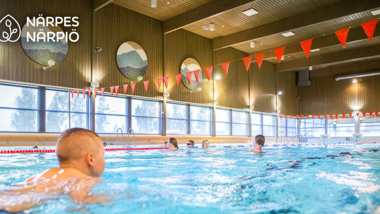 Bild från bassäng med personer som simmar.