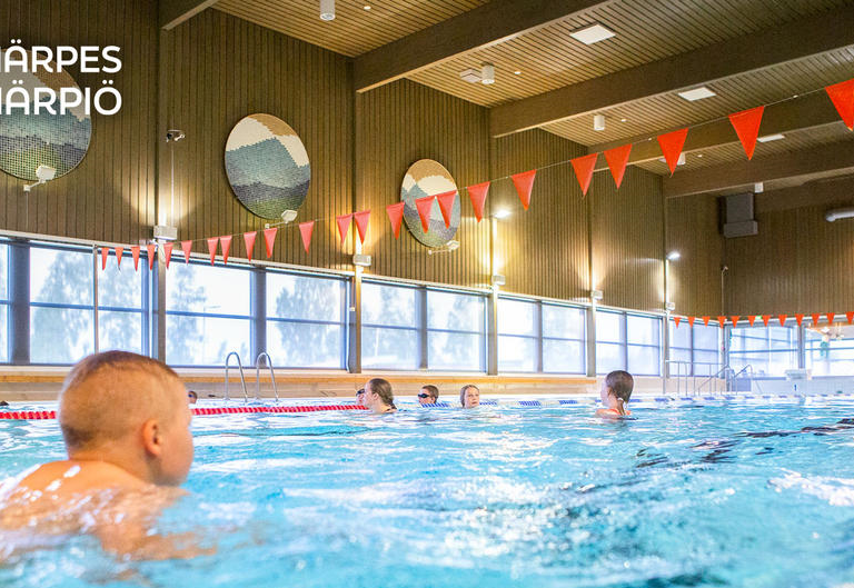 Bild från bassäng med personer som simmar.